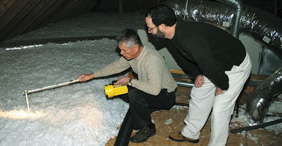 Bud Cole, left, Gibson Electric Membership Corporation residential energy services specialist, examines a member’s attic insulation. Maintaining adequate insulation levels helps save energy — and money — year-round.