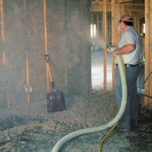 A worker installs cellulose insulation, which is second only to foam insulation in energy efficiency. Photograph by Gary Bean