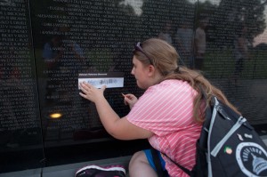 Symphony Mullins of Mountain Electric Cooperative makes a rubbing at the Vietnam Veterans Memorial.