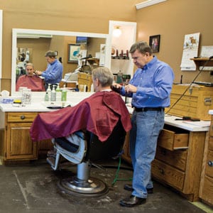 Kent Scoles, seated, is just one of Randall Hall’s regular Palace Barber Shop customers who eagerly awaits the holiday display.