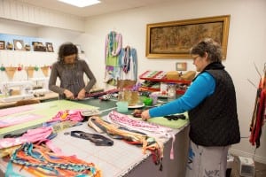 Kristi Smith, left, and Lisa Salazar “deconstruct “T-shirts for future use. They will use nearly every piece of fabric — from the sleeves to the hems — to create one-of-a kind garmets for sale.