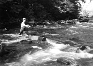 A fisherman in the early 1900s wets a line in the Little Pigeon River where today’s guests of the modern Greystone Lodge, below, can continue the timeless vacation tradition.