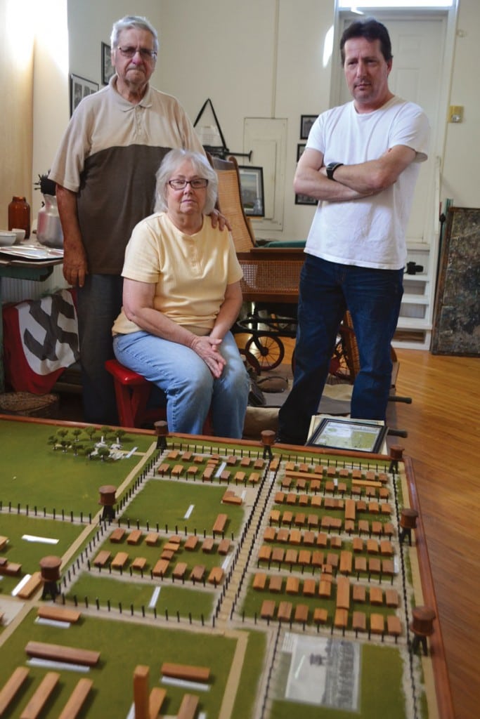 From left, Robert, Nita and Sean Boring, who collectively run the Military Memorial Museum, show a model of the POW camp created by many volunteers in Crossville. Photograph courtesy of Tennessee History for Kids