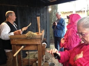 Visitors witness broom-making at a living history demonstration.