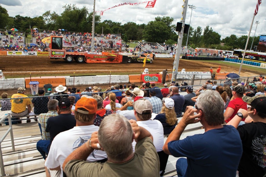 The crowd tries to dull the roar of an engine. If you plan to attend, ear protection is a must.