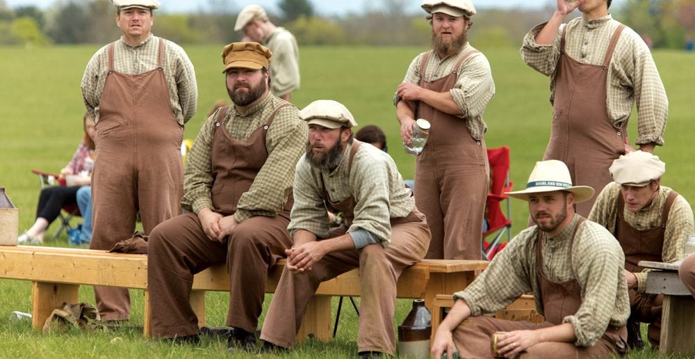 Distiller teammates watch during a rare break in the action. Vintage base ball is known for its good-natured camaraderie, with ballists even cheering on their opponents and complimenting them on good plays.