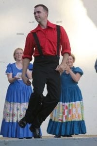 Nathan Horton demonstrates buck dancing, a freestyle clog, during a performance by the Cripple Creek Cloggers. His wife, Carey, and Ann Mattox clap along in encouragement.