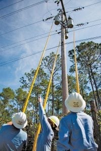 Middle Tennessee EMC linemen help to restore power to Clay Electric Cooperative members in Palatka, Florida. Linemen use hot sticks to reenergize three transformers.